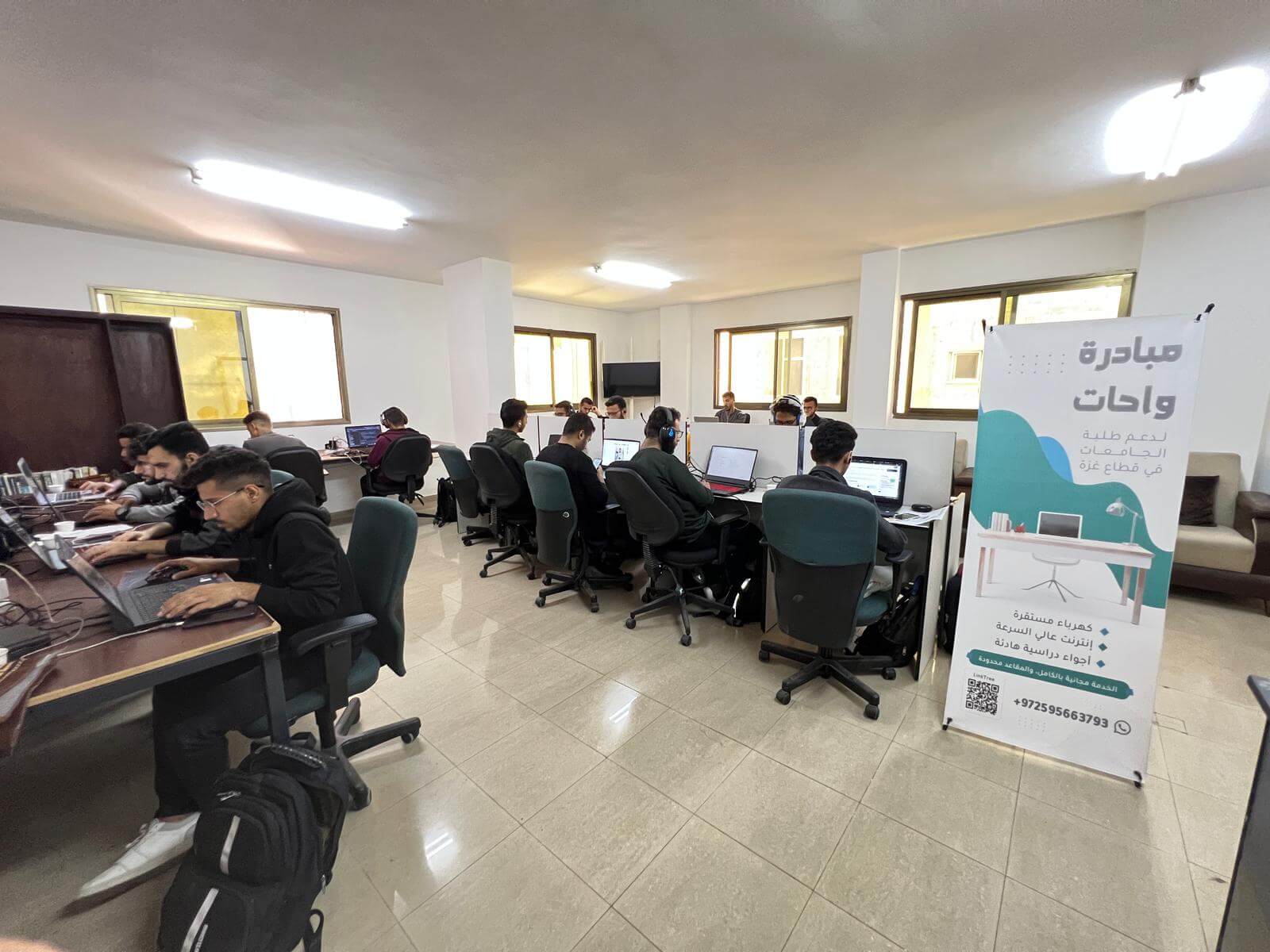 مساحة عمل واسعة مع طلاب يعملون على أجهزة الكمبيوتر