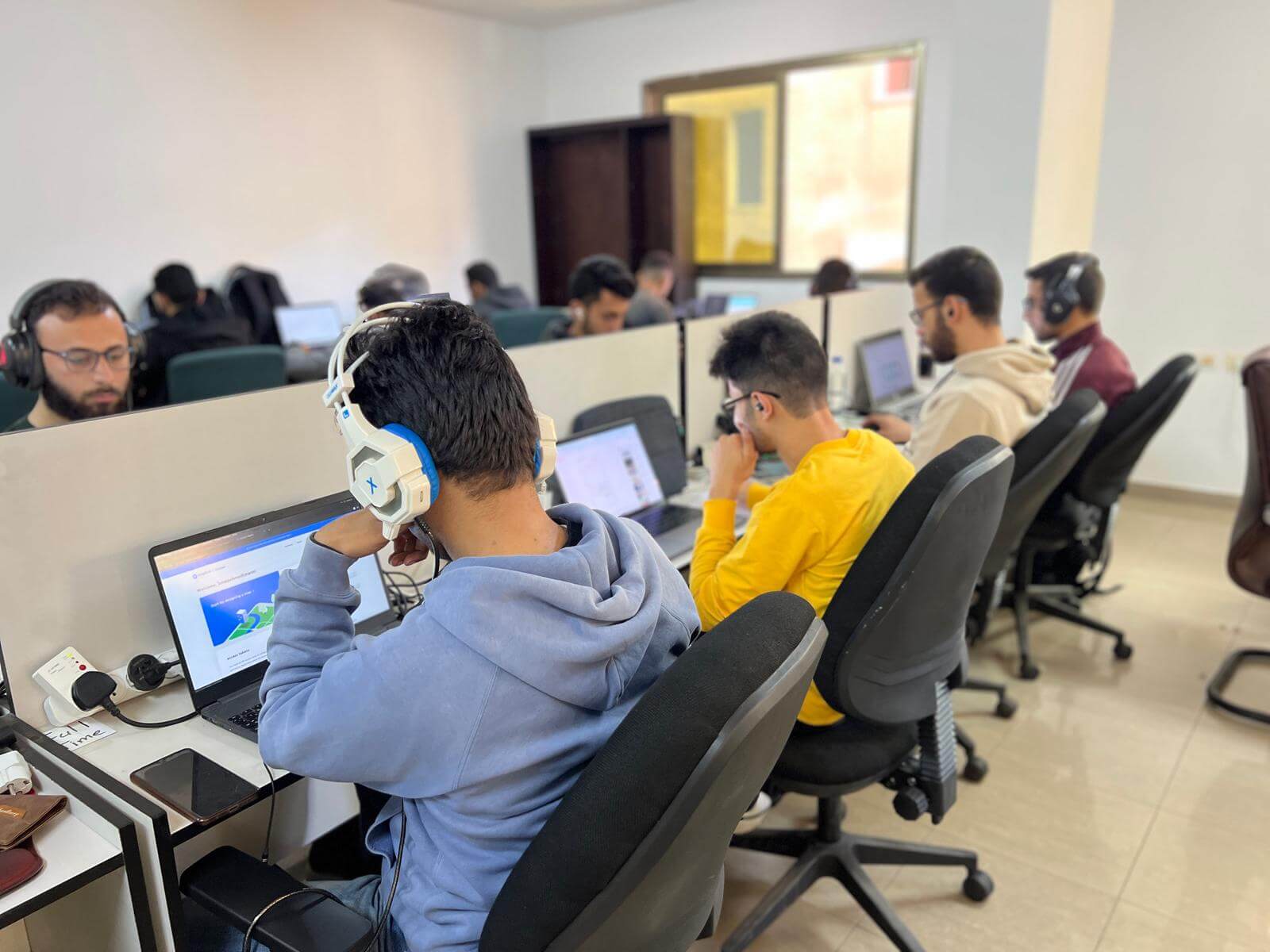 طلاب يستخدمون سماعات الرأس في بيئة عمل مركزة